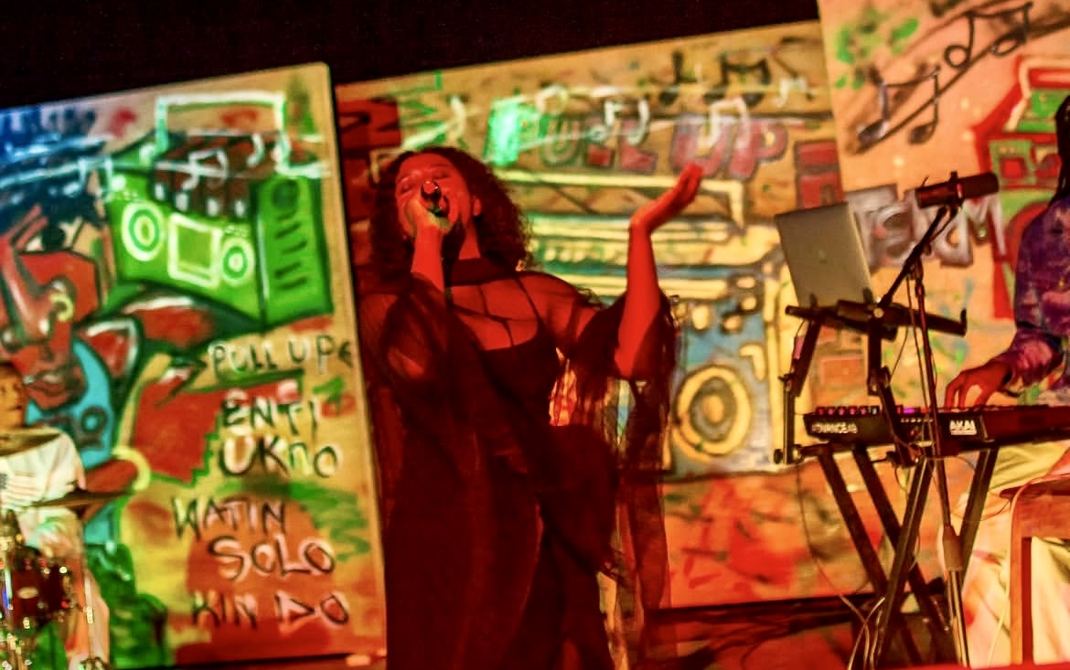 Iyabode performing live on a colourful stage